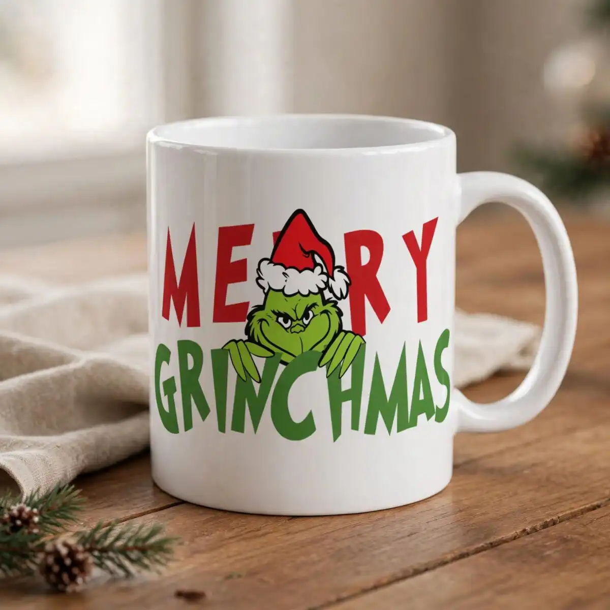 merry grinchmas png design with the grinch and santa hat a green furry creature wearing a Santa hat, peeking over green text, with red text above design printed on a plain product mo