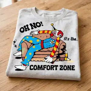 cartoon clown like figure svg shirt design: lazy halloween comfort zone clown on a couch cartoon clown like figure svg design printed on a plain product mockup