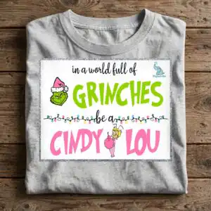 a quote about being kind with a green character wearing a Santa hat and a small girl holding an ornament, framed by glitter d