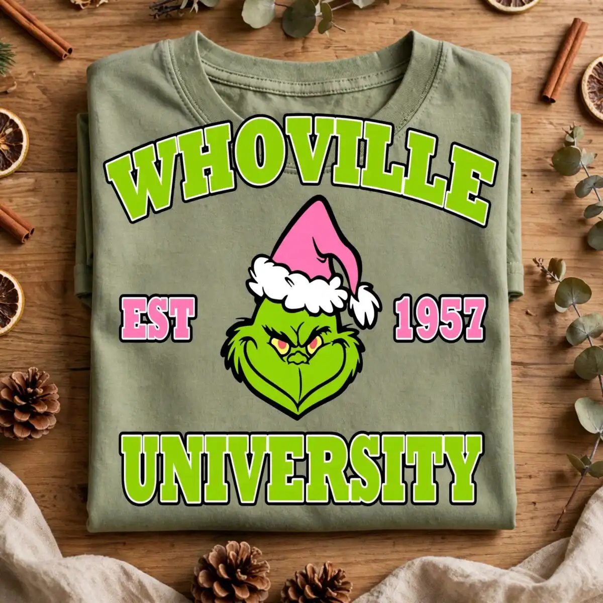 pink grinch whoville est university christmas svg for crafters a green creature wearing a pink Santa hat with text around it design printed on a plain product mockup