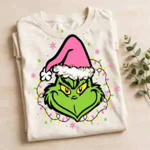 a green furry face with yellow eyes wearing a pink Santa hat and Christmas lights design printed on a plain product mockup