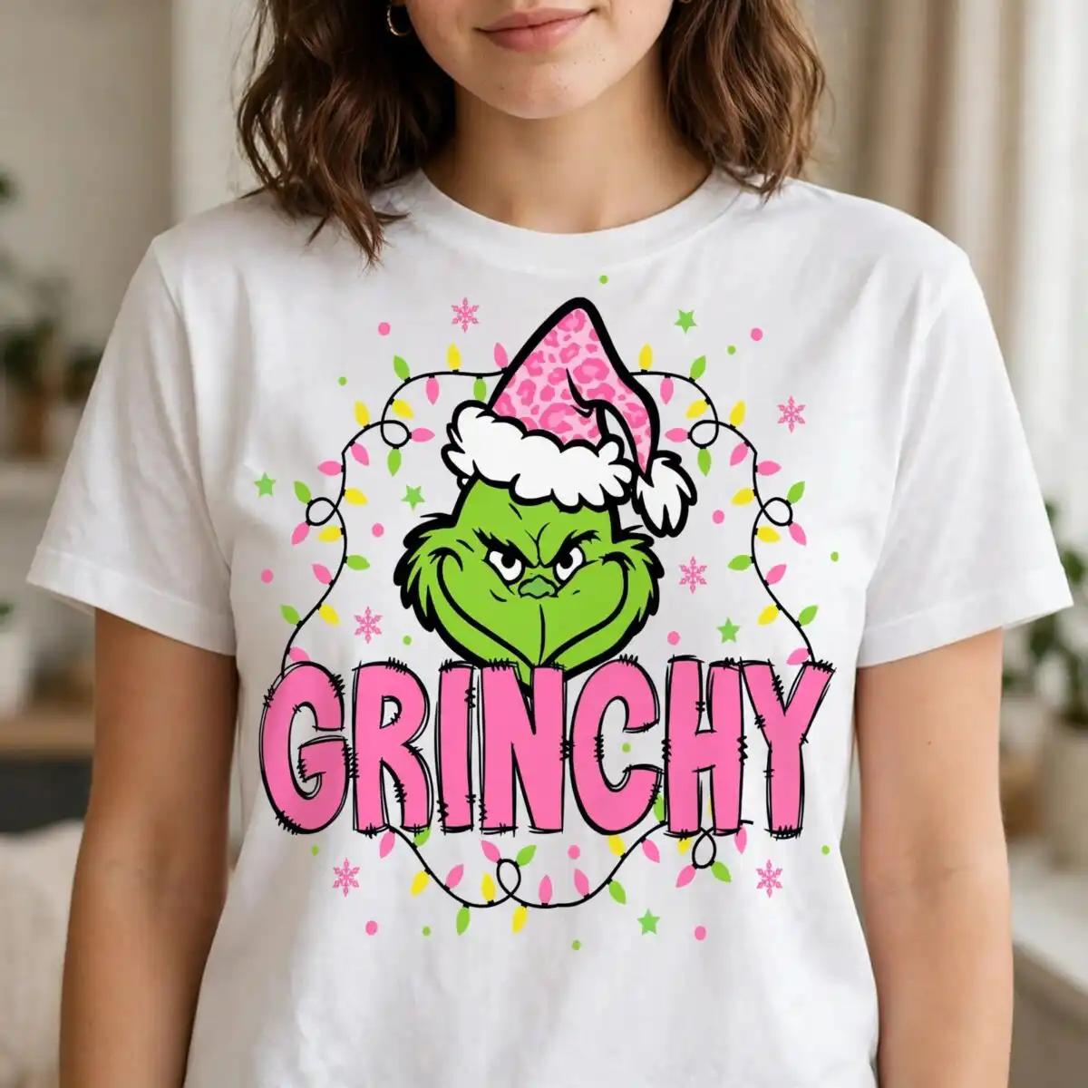 grinchy green furry face pink sublimation design for christmas crafts A green furry face wearing a pink leopard print Santa hat, surrounded by Christmas lights and snowflakes, with the word GRINC