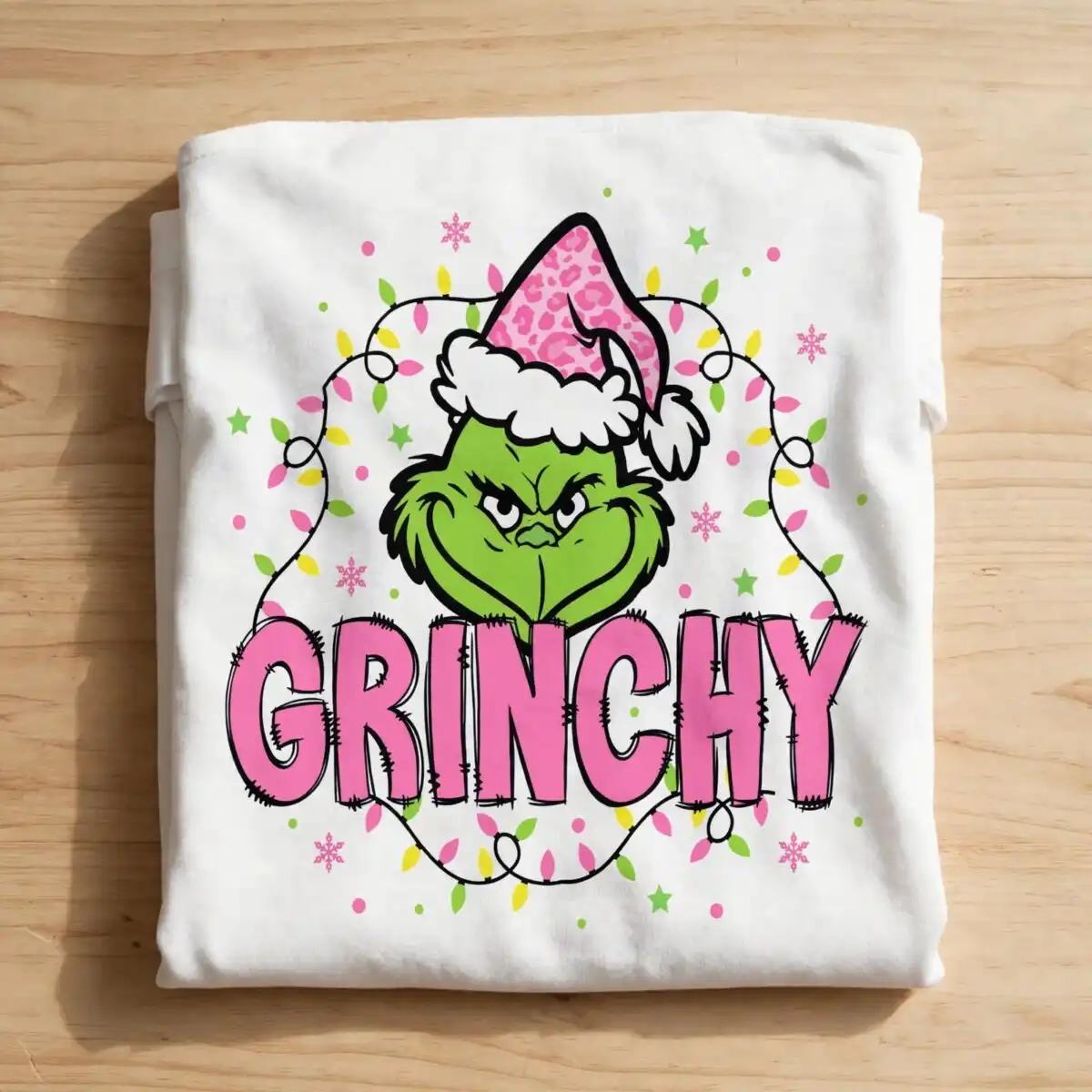 grinchy green furry face pink sublimation design for christmas crafts A green furry face wearing a pink leopard print Santa hat, surrounded by Christmas lights and snowflakes, with the word GRINC